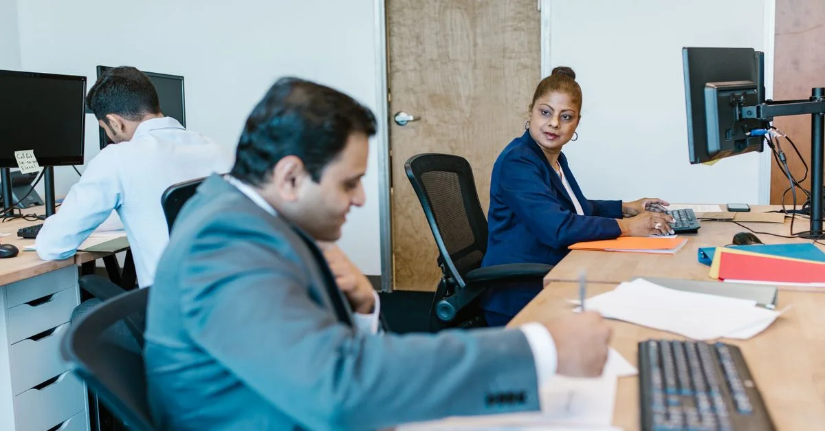 Professionnels divers collaborant dans un cadre de bureau moderne, favorisant le travail d'équipe.
